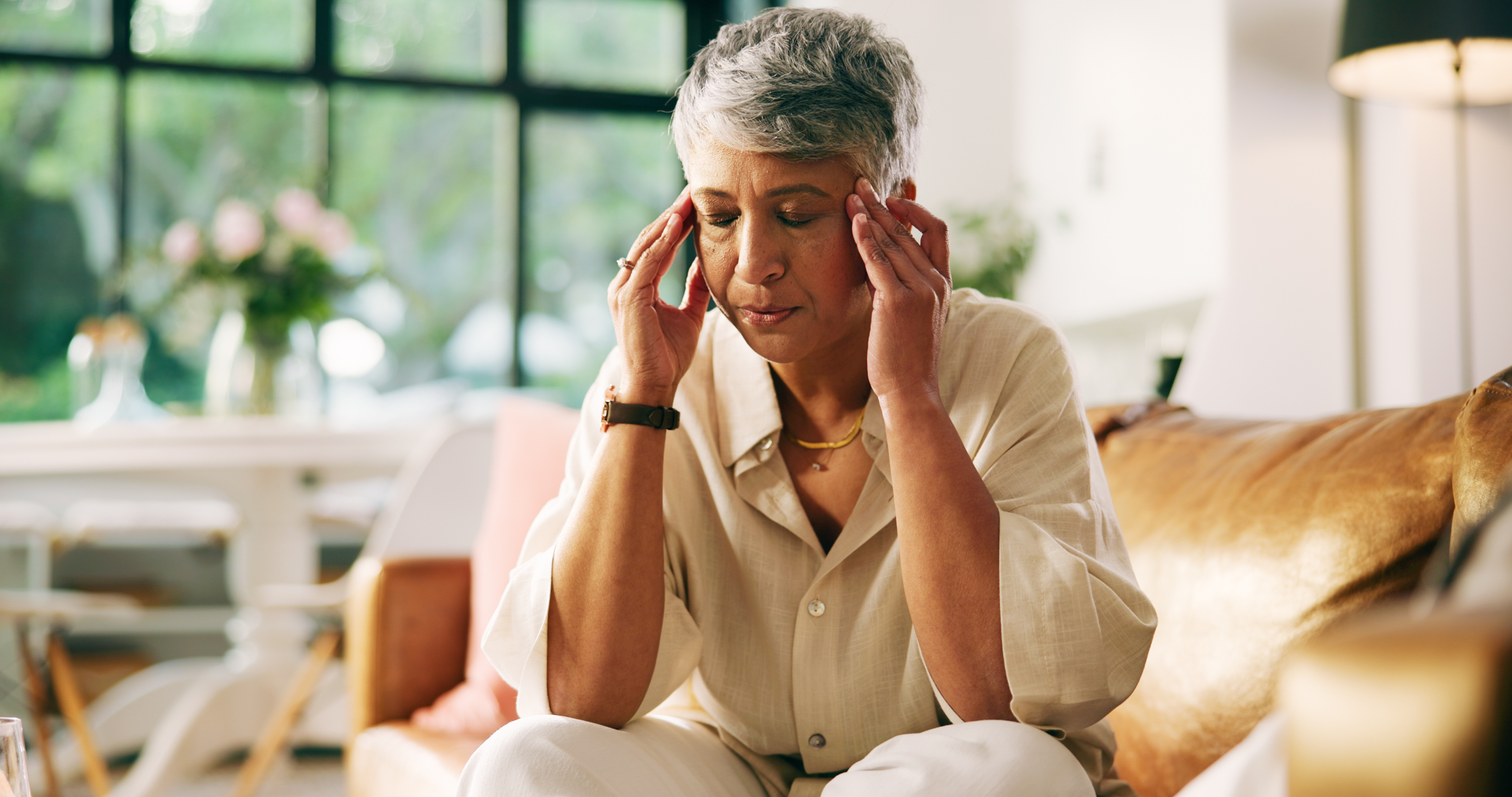 Elderly woman touching her head with confusion