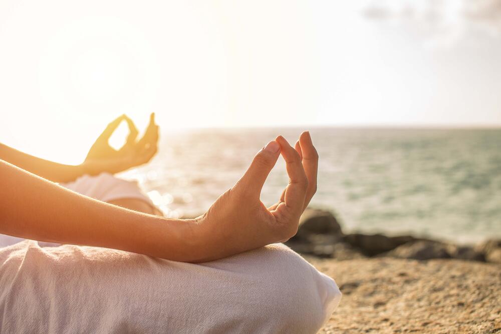 Woman meditating on the beach 