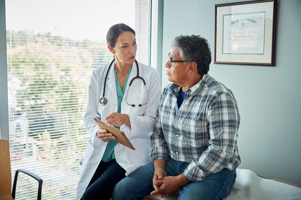 Man speaking with doctor in in doctor's office