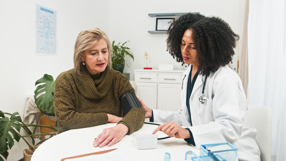 Doctor taking patient's blood pressure