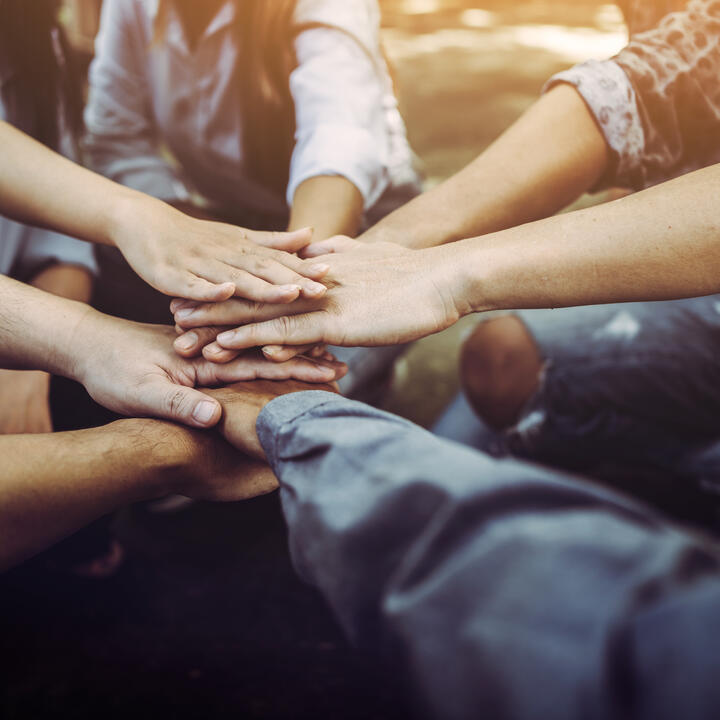 Diverse people joining hands, teamwork